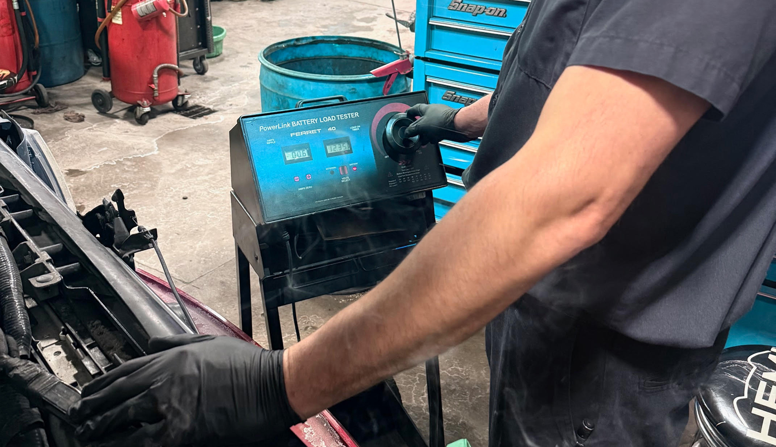 Technician performing a car battery test with a diagnostic tool