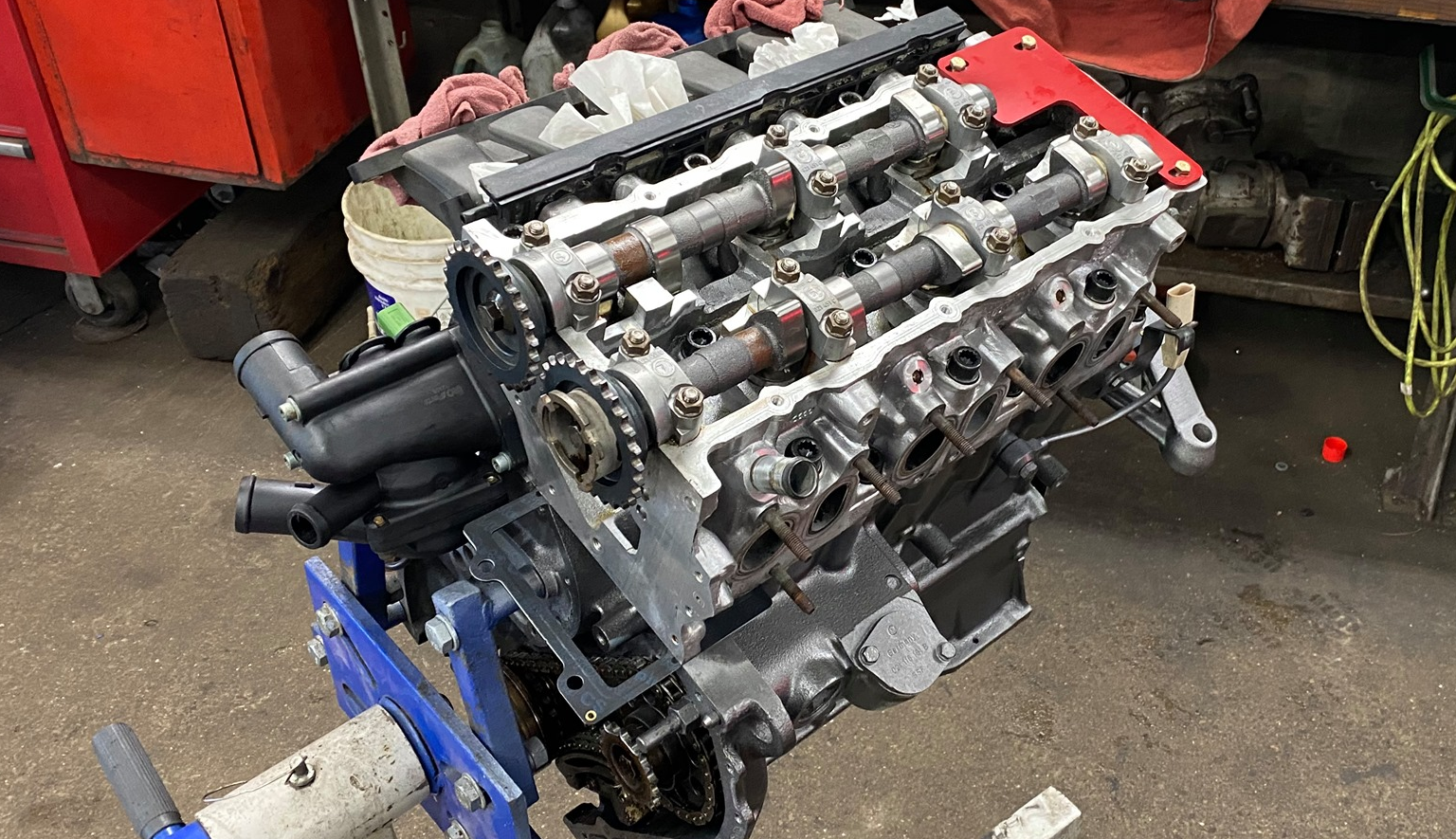 Partially disassembled car engine on an engine stand, showing camshafts and cylinder head during professional engine repair at Lonsbury Garage.