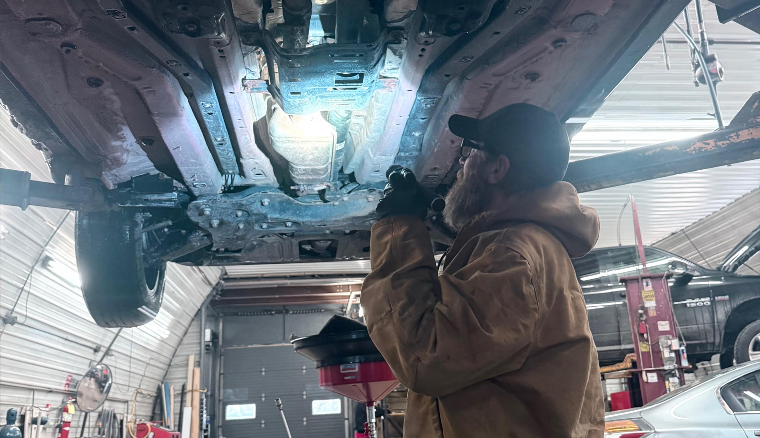 Diesel technician inspecting DPF and exhaust aftertreatment system for faults and leaks