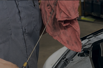 Technician confirming proper oil level during inspection