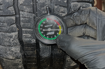 Tread depth gauge checking tire tread depth for replacement recommendation